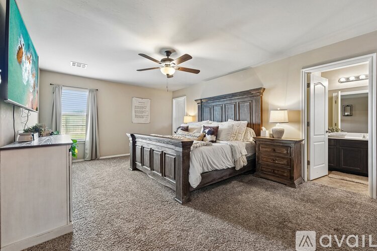 A bedroom with a large bed and a ceiling fan.