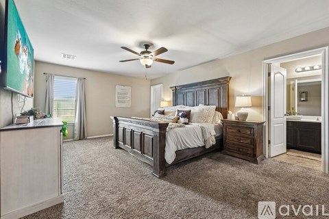A bedroom with a large bed and a ceiling fan.