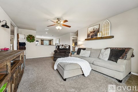 A living room with a grey couch and a wooden coffee table.