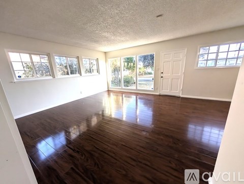 A room with a wooden staircase and a window with a view of the outside.