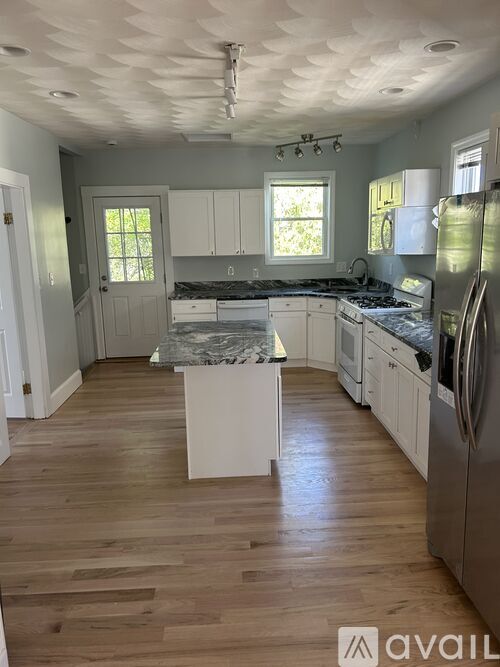 A kitchen with wooden floors and stainless steel appliances.