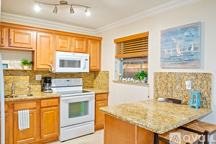 A kitchen with wooden cabinets and granite countertops.