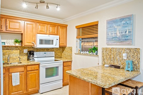 A kitchen with wooden cabinets and granite countertops.