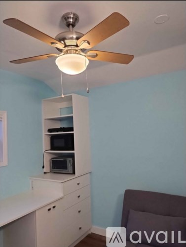 A kitchen with a ceiling fan and a microwave oven.