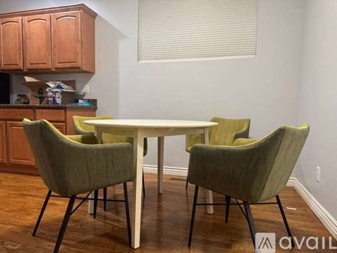 A dining room with a white table and green chairs.