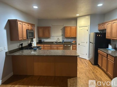A kitchen with wooden cabinets and a granite countertop.