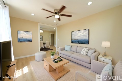 A living room with a couch, a coffee table, and two paintings on the wall.