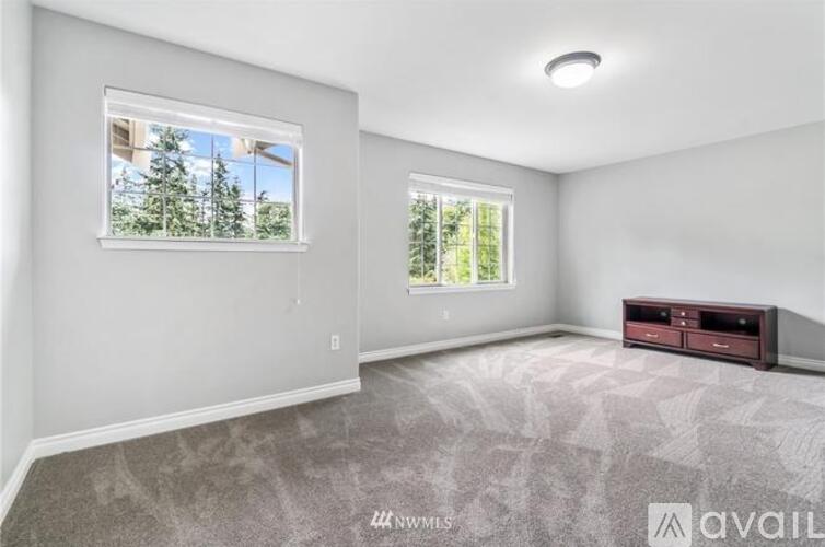 A spacious room with a large window and a flat-screen TV.