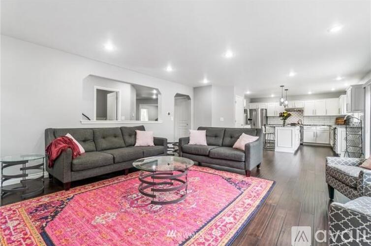 A living room with a grey sofa and a pink rug.