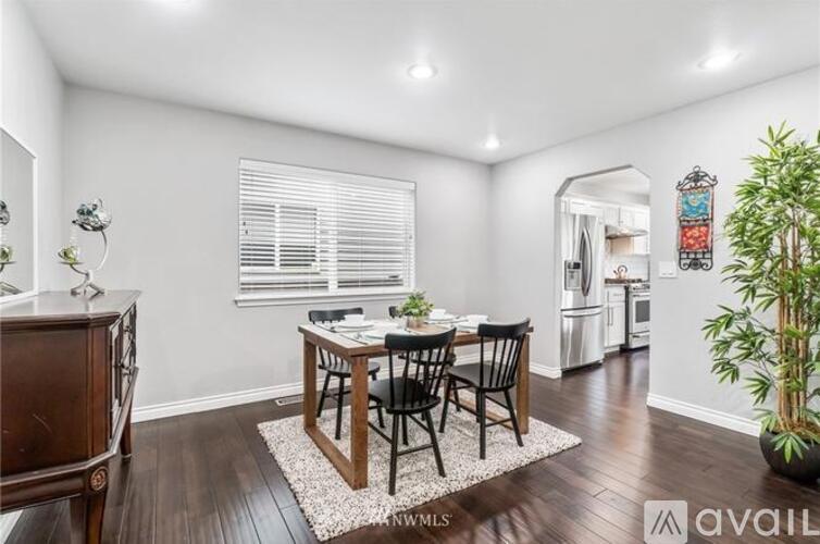 A dining room with a wooden table and chairs.