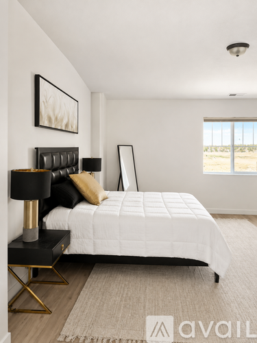 A bedroom with a white bed and a black lamp.