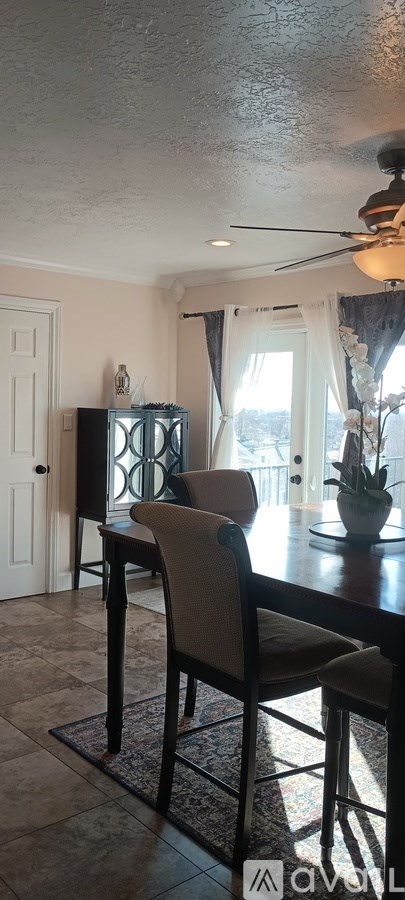 A dining room with a table and chairs.