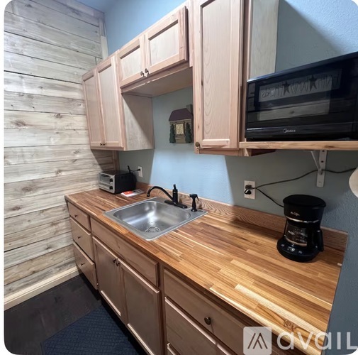 A kitchen with wooden cabinets and a wooden counter top.