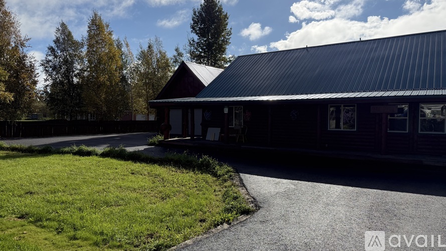 A building with a dark roof and a gravel driveway in front.
