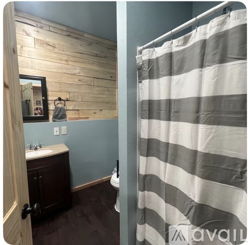 A bathroom with a striped shower curtain.