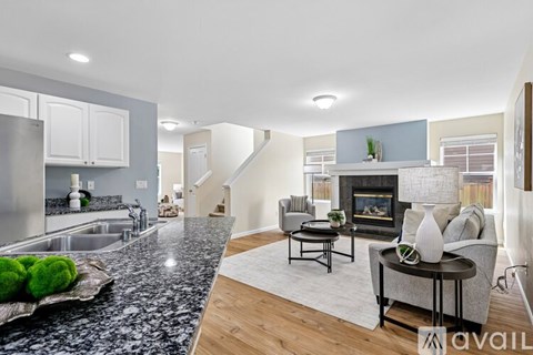 A modern kitchen with granite countertops and a dining area with a table and chairs.