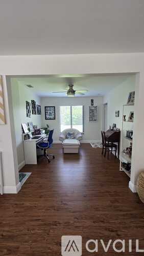 A living room with a couch, chairs, and pictures on the wall.
