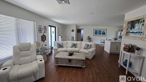 A living room with a white chair and a white couch.