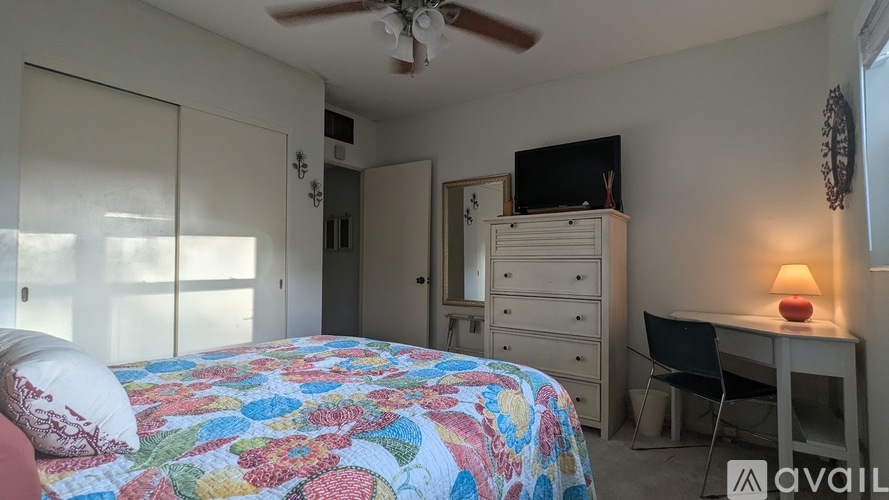 A bedroom with a bed, desk, and chair.
