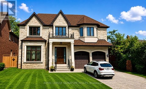 A white car is parked in front of a two-story house.