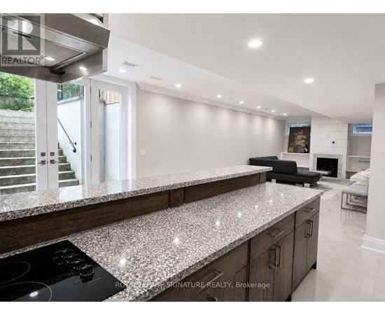 A modern kitchen with a granite countertop and stainless steel appliances.