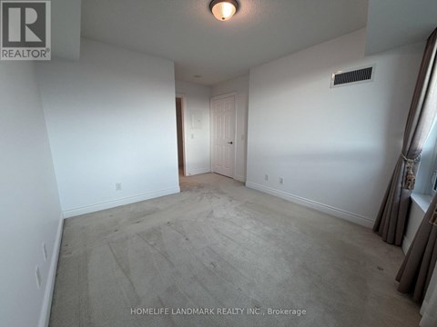 A room with a carpet floor and a white wall.