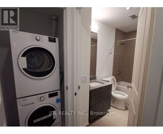 A white washer and dryer in a small bathroom.