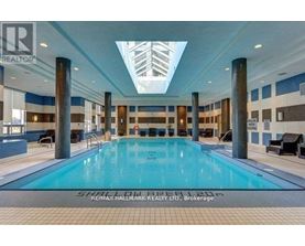 A large indoor swimming pool with a skylight above it.