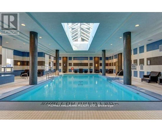 A large indoor swimming pool with a skylight above it.