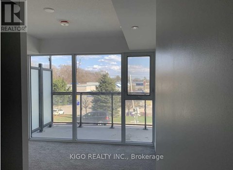 A room with a view of a parking lot through a glass door.