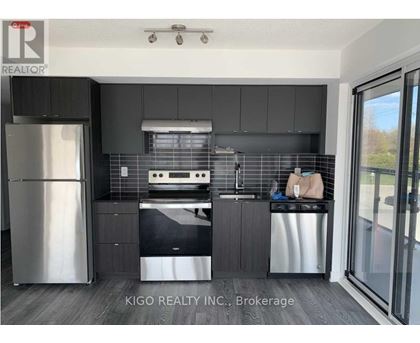 A modern kitchen with a stainless steel refrigerator and dishwasher.