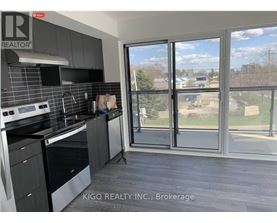 A kitchen with a large window overlooking a grassy area.
