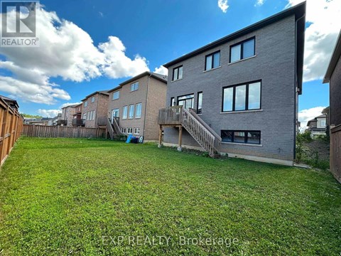 A large grassy yard in front of a grey building.
