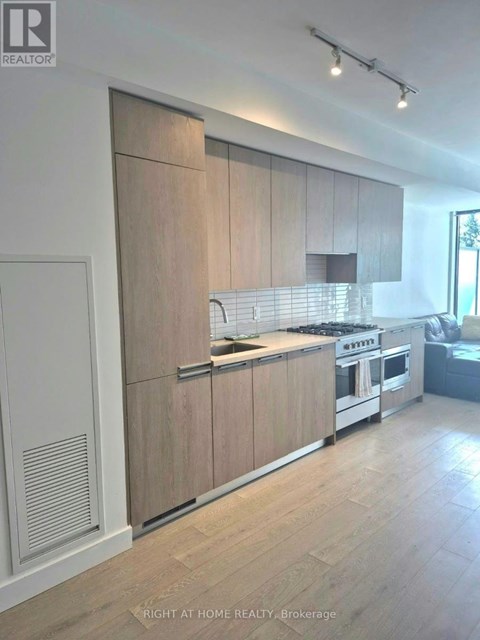 A modern kitchen with wooden cabinets and stainless steel appliances.