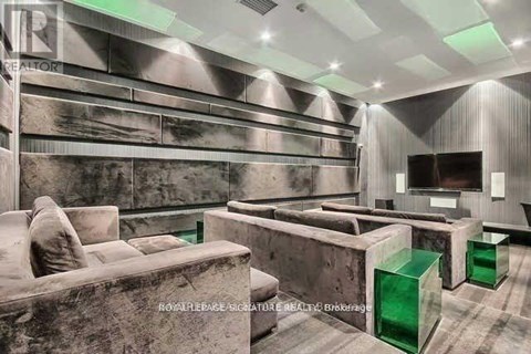 A modern living room with a grey couch and green side tables.