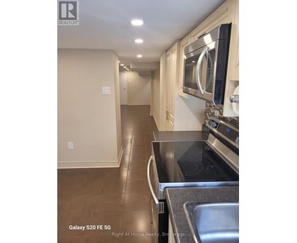 A kitchen with a black counter top and a stainless steel sink.
