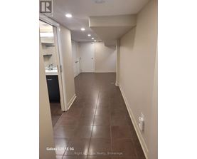 A hallway with tile flooring and white walls.