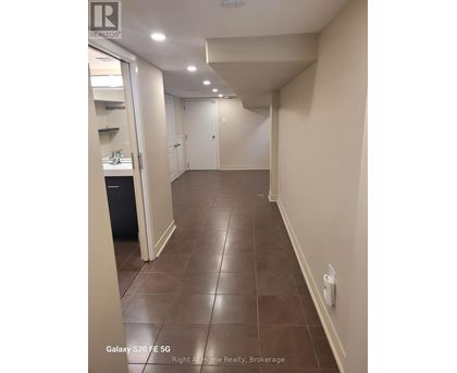 A hallway with tile flooring and white walls.