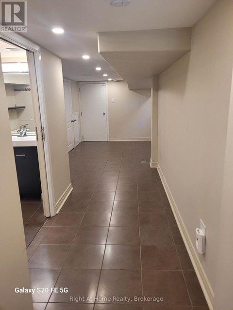 A hallway with tile flooring and white walls.