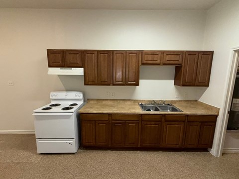 A white stove and oven in a kitchen with brown cabinets.