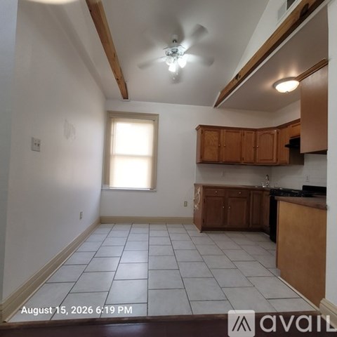 A kitchen with wooden cabinets and a ceiling fan.
