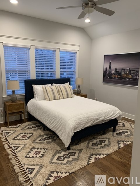 A bedroom with a large bed and a ceiling fan.