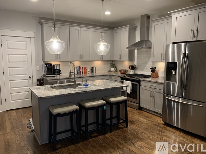 A modern kitchen with a large island and stainless steel appliances.