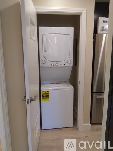 A small white fridge in a narrow space.