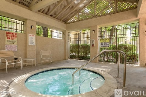 A pool area with a warning sign for a life guard on duty.