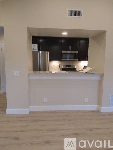 A kitchen with black cabinets and stainless steel appliances.
