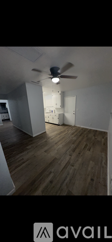 A room with wooden flooring and a ceiling fan.