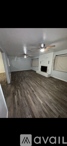 A room with wooden flooring and a ceiling fan.