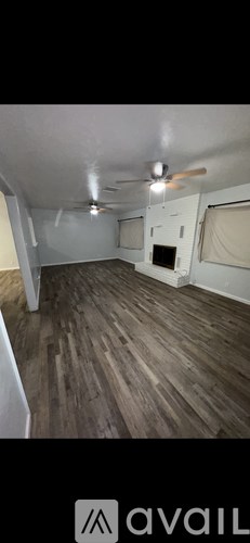 A room with wooden flooring and a ceiling fan.