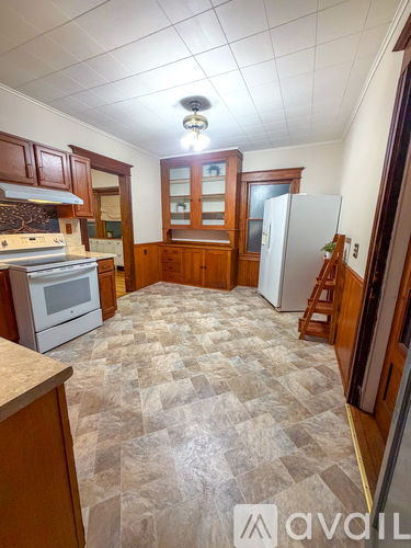 A kitchen with wooden cabinets and a checkered floor.